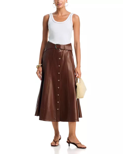 Full-length view of a model wearing the Cinq à Sept Briony vegan leather skirt in Espresso styled with a white tank top and brown heels.
